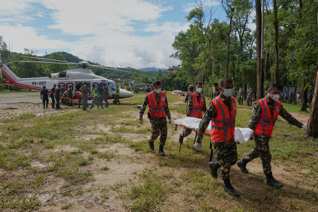 Nepal's army personnel carry a victim from the flash floods in a body bag at a helipad in an army camp in Nuwakot district, Nepal, Wednesday, Sept. 2, 2026. (AP Photo/Rajesh Kumar Singh)