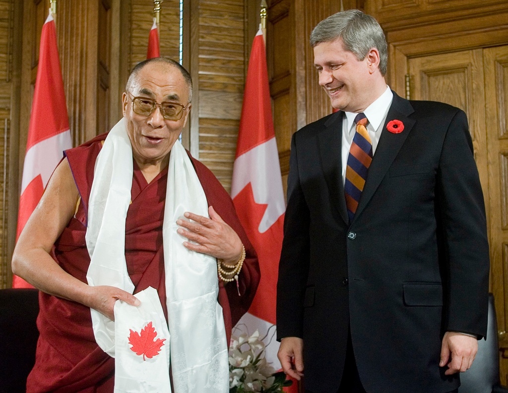 FILE - Tibetan spiritual leader the Dalai Lama shows off a Kata with a Canadian Maple Leaf given to him by Canadian Prime Minister Stephen Harper prior to their meeting on Parliament Hill in Ottawa Monday, Oct. 29, 2007. (Tom Hanson/Canadian Press via AP, File)