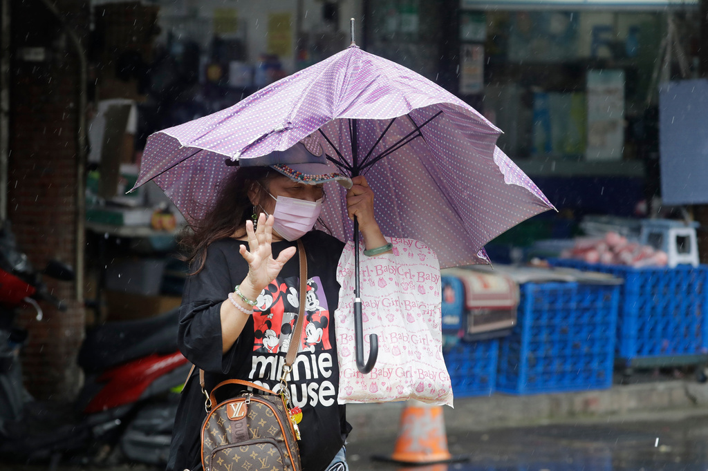A woman struggles with winds generated by Typhoon Champi in Taipei, Taiwan, Friday, Oct. 23, 2026. (AP Photo/ Chiang Ying-ying)