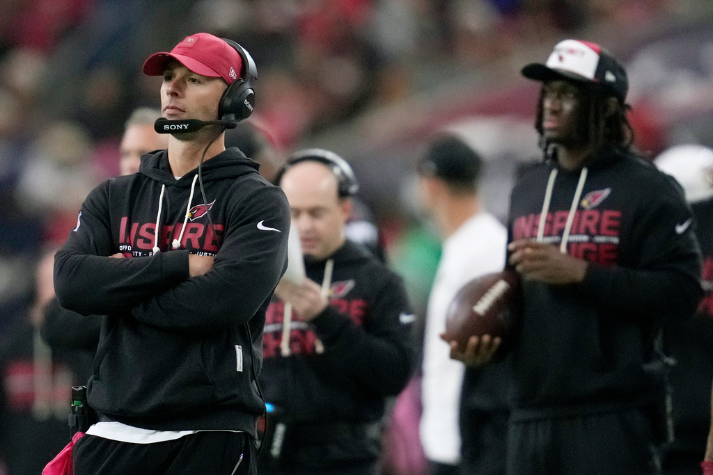 Arizona Cardinals head coach Jonathan Gannon, left, and injured Cardinals wide receiver Marvin Harrison Jr. watch the action on the field during the first half of an NFL football game against the Houston Texans Sunday, Dec. 14, 2025, in Houston. (AP Photo/Ashley Landis)