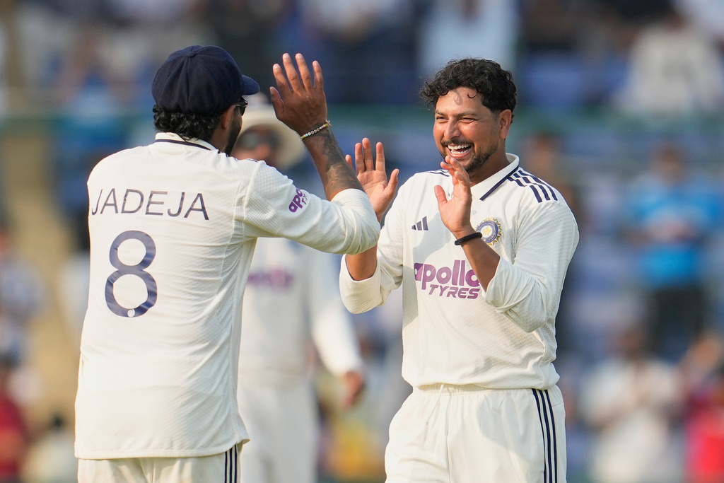 India's Kuldeep Yadav and Ravindra Jadeja celebrate the dismissal of West Indies' Alick Athanaze on the second day of the second cricket test match between India and West Indies at the Arun Jaitley Stadium in New Delhi, India, Saturday, Oct.11, 2025. (AP Photo/Manish Swarup)