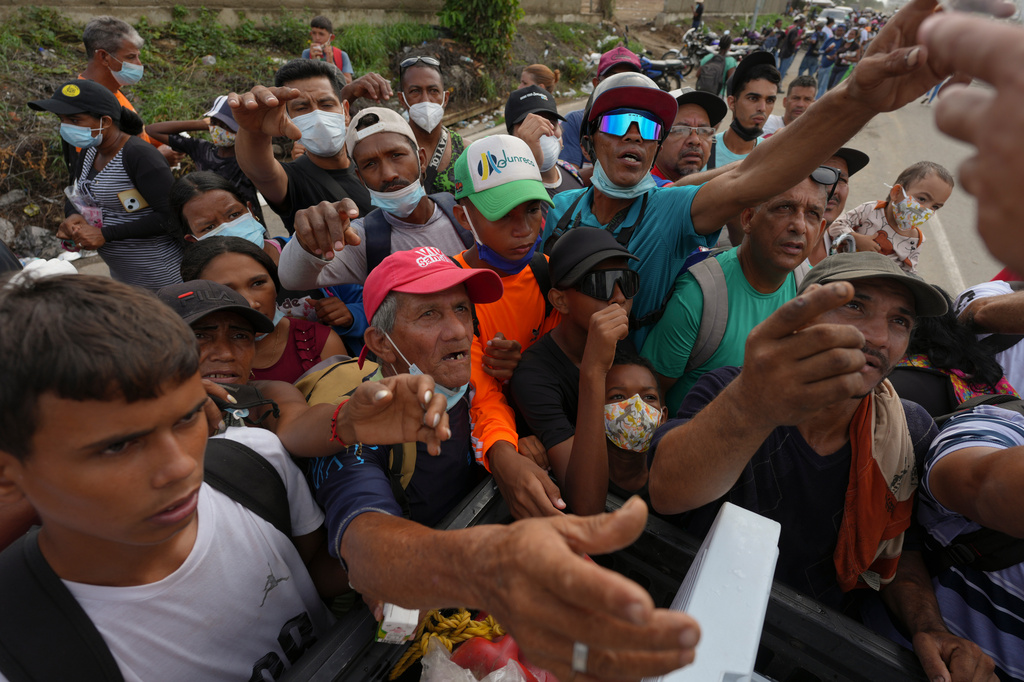 FILE - People reach out to receive supplies from volunteers, days after an earthquake struck La Guaira, Venezuela, June 30, 2026. (AP Photo/Matias Delacroix, File)
