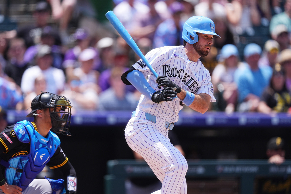 Colorado Rockies' Sterlin Thompson, right, hits an RBI ground ball off Pittsburgh Pirates starting pitcher Jared Jones in the second inning of a baseball game Sunday, June 21, 2026, in Denver. (AP Photo/David Zalubowski)