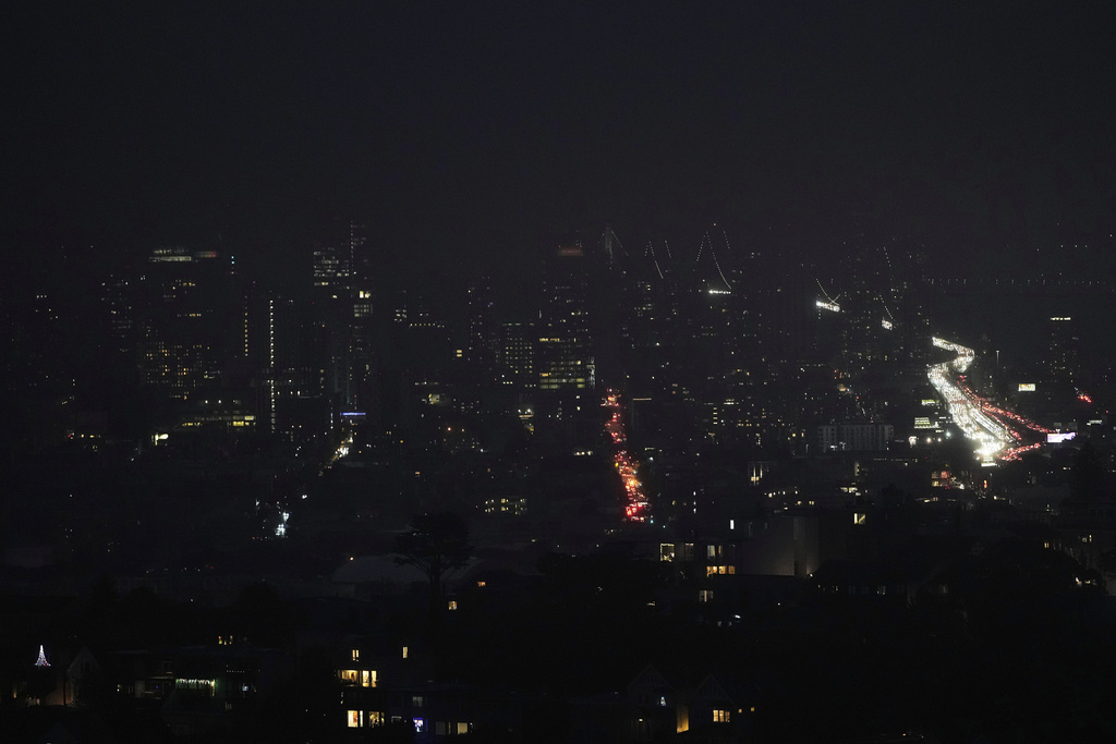 Fog and power outages darken the skyline as traffic moves in San Francisco, Saturday, Dec. 20, 2025. (AP Photo/Jeff Chiu)