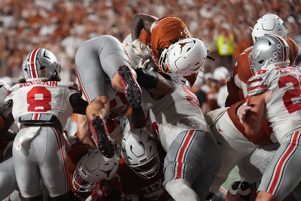 Texas running back Hollywood Smothers, top center, dives for the winning touchdown against Ohio State during the first half of an NCAA college football game in Austin, Texas, Saturday, Sept. 12, 2026. (AP Photo/Eric Gay)