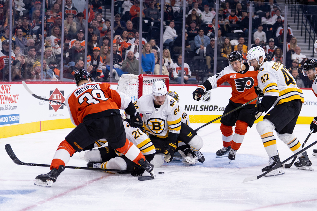 Boston Bruins' Tanner Jeannot, center, tries to clear the puck during the second period of an NHL hockey game Saturday, Feb. 28, 2026, in Philadelphia. (AP Photo/Chris Szagola)