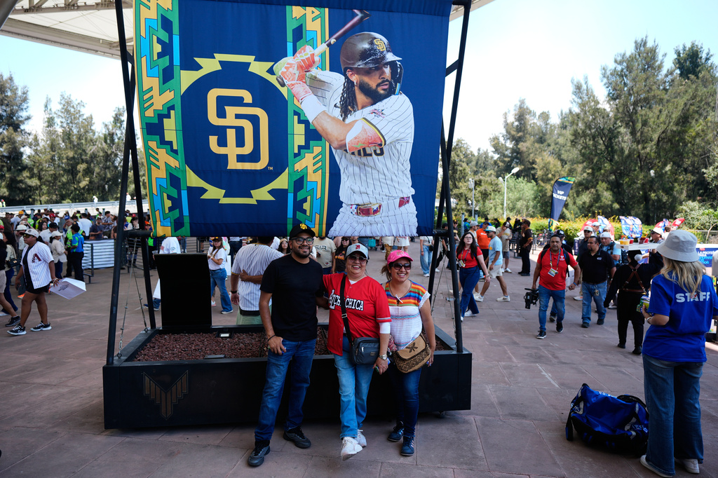 Fans pose with a promotional billboard ahead of the San Diego Padres baseball game against Arizona Diamondbacks in Mexico City, Sunday, April 26, 2026. (AP Photo/Fernando Llano)