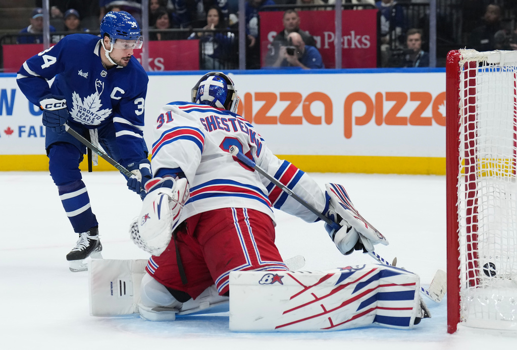 Toronto Maple Leafs' Auston Matthews (34) scores the winning goal past New York Rangers goaltender Igor Shesterkin (31) during overtime NHL hockey game action in Toronto, Thursday, Oct. 16, 2025. (Nathan Denette/The Canadian Press via AP)