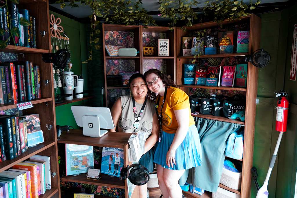 Kristen Quanrud, left, and Anne Hampton, owners of Wandering Quills Bookshop, pose inside of their mobile bookstore in Columbus, Ohio, on April 12, 2026. (Matt Deaton/Wandering Quills Bookshop via AP)