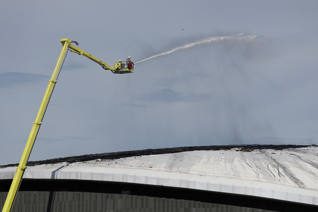 Firefighters work to control a fire on the roof of Rio de Janeiro's Olympic Park velodrome, Wednesday, April 8, 2026. (AP Photo/Bruna Prado)