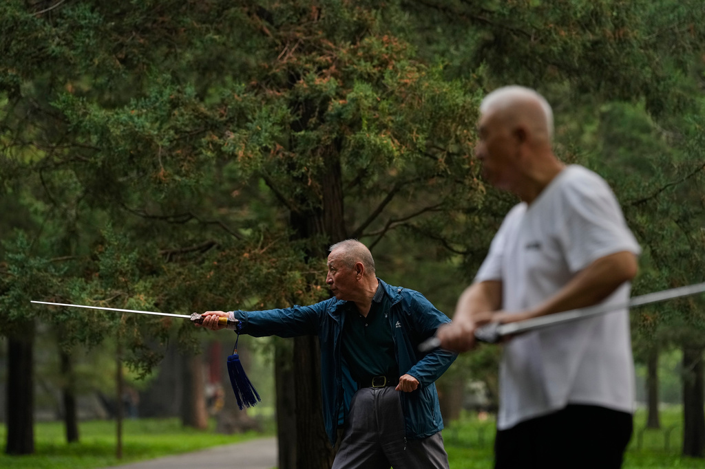 Elderly men practice Tai Chi with swords at a park near the Temple of Heaven in Beijing, Thursday July 9, 2026. (AP Photo/Andy Wong)