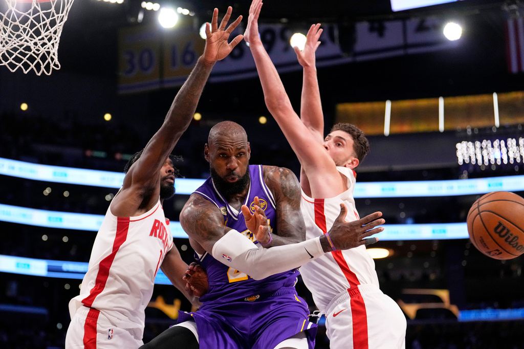 Los Angeles Lakers forward LeBron James, center, passes the ball as Houston Rockets forward Tari Eason, left, and center Alperen Sengun defend during the first half in Game 5 of a first-round NBA playoffs basketball series Wednesday, April 29, 2026, in Los Angeles. (AP Photo/Mark J. Terrill)