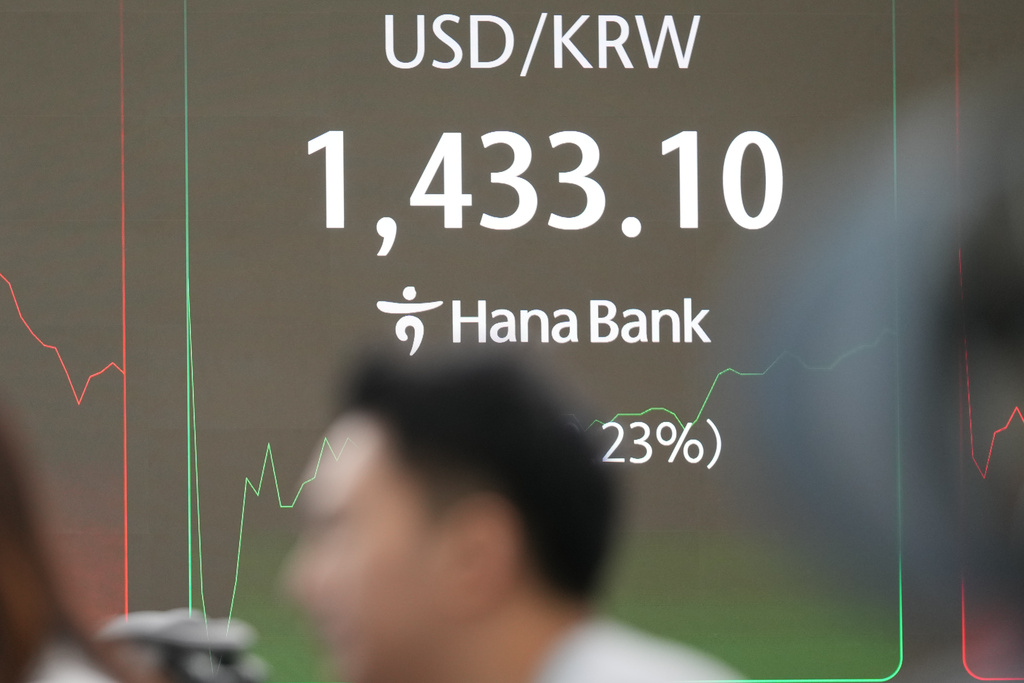 A dealer watches computer monitors near the screen showing the foreign exchange rate between U.S. dollar and South Korean won at a dealing room of Hana Bank in Seoul, South Korea, Tuesday, Dec. 30, 2025. (AP Photo/Lee Jin-man)