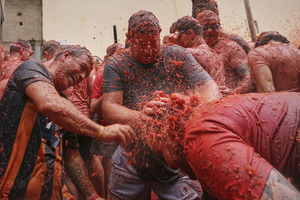 Revelers throw tomatoes at each other during the annual "Tomatina" tomato fight fiesta, in the village of Bunol near Valencia, Spain, Wednesday, Aug. 27, 2025. (AP Photo/Alberto Saiz)