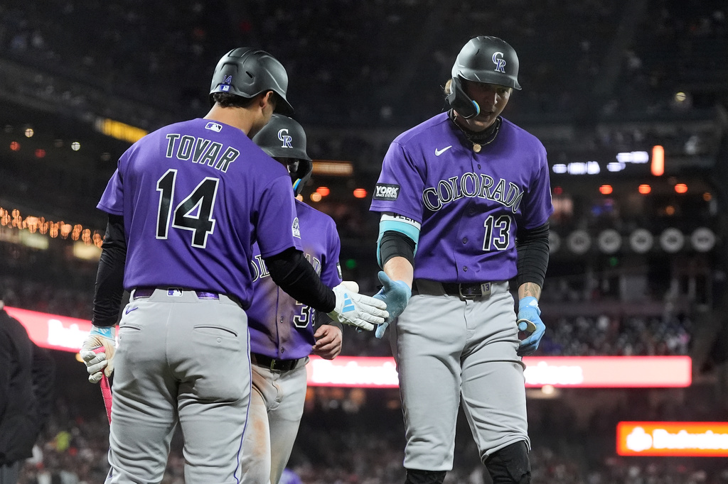 Colorado Rockies' Zac Veen (13) is congratulated by Ezequiel Tovar (14) after hitting a two-run home run that also scored Connor Norby, rear, during the sixth inning of a baseball game against the San Francisco Giants, Friday, Aug. 14, 2026, in San Francisco. (AP Photo/Jeff Chiu)