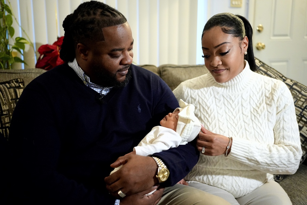 Leon and Mercedes Wells hold their newborn daughter Alena at their home in the Chicago suburb of Dolton, Ill. on Friday, Nov. 28, 2025. (AP Photo/Mark Vancleave)