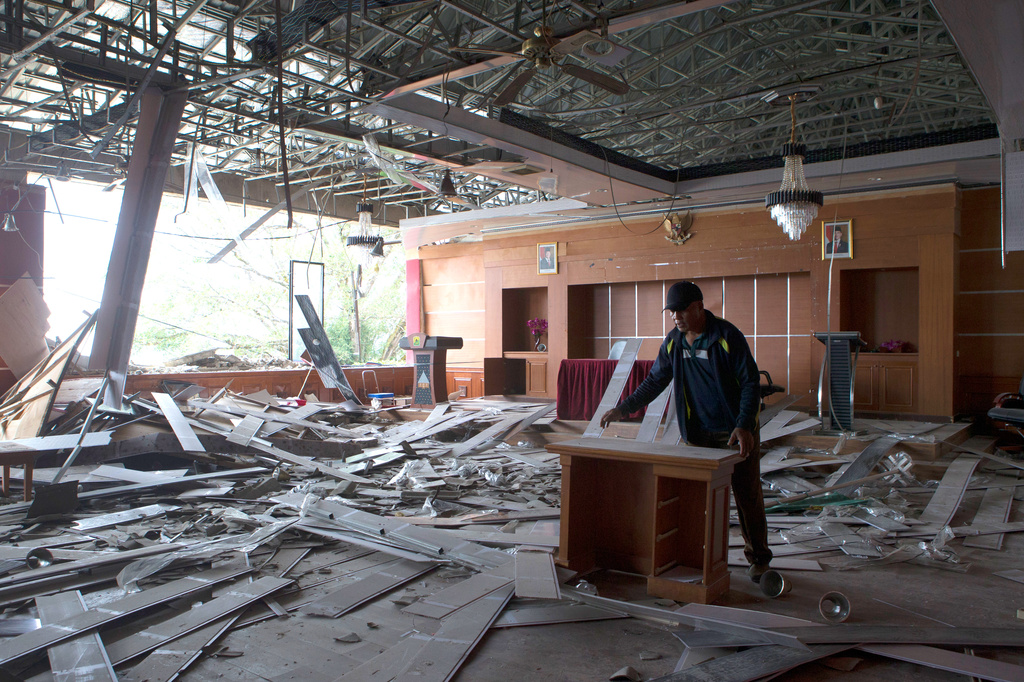 A worker removes a broken furniture inside a room at the local government office which was damaged during an earthquake in Ruteng, East Nusa Tenggara province, Indonesia, Sunday, Aug. 16, 2026. (AP Photo/Firdia Lisnawati)