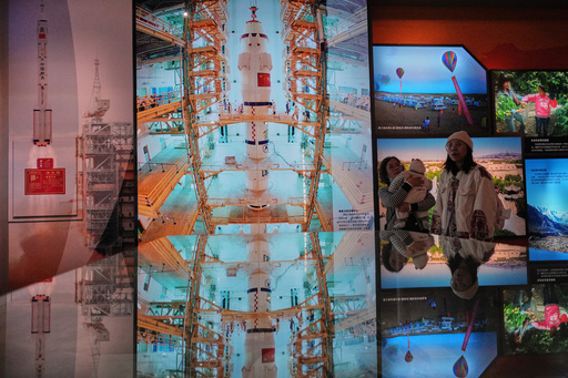 A Chinese family tour a museum showing pictures of China's Long March 2F rocket for the Shenzhou manned space mission as China going to send three astronauts for their routine mission to the space station, in Jiayuguan in China's northwestern Gansu province, Wednesday, Oct. 29, 2025. (AP Photo/Andy Wong) A Chinese family tour a museum showing pictures of China's Long March 2F rocket for the Shenzhou manned space mission as China going to send three astronauts for their routine mission to the space station, in Jiayuguan in China's northwestern Gansu province, Wednesday, Oct. 29, 2025. (AP Photo/Andy Wong)