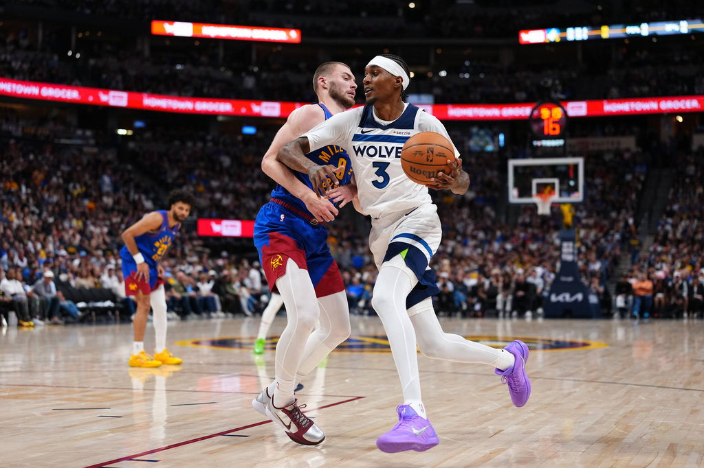 Minnesota Timberwolves Jaden McDaniels (3) drives to the basket against Denver Nuggets guard Christian Braun (0) during the second half in Game 2 of a first-round NBA playoffs basketball series Monday, April 20, 2026, in Denver. (AP Photo/Jack Dempsey) CORRECTION Correct to Julius Randle in stead of Julius Randle.