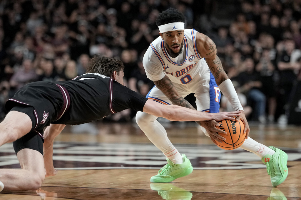 Texas A&M forward Zach Clemence, left, steals the ball away from Florida guard Boogie Fland (0) during the first half of an NCAA college basketball game Saturday, Feb. 7, 2026, in College Station, Texas. (AP Photo/Sam Craft)