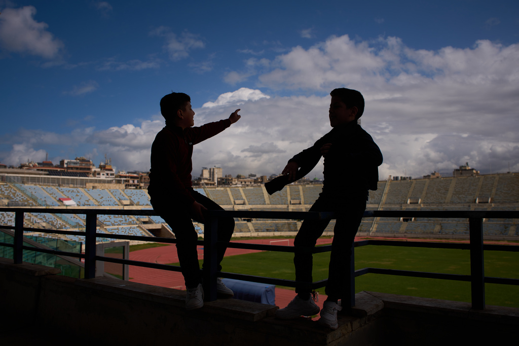 Displaced children talk inside Camille Chamoun Sports City Stadium, now used as a shelter for people displaced by Israeli airstrikes in southern Lebanon, in Beirut, Lebanon, Monday, March 30, 2026. (AP Photo/Emilio Morenatti)