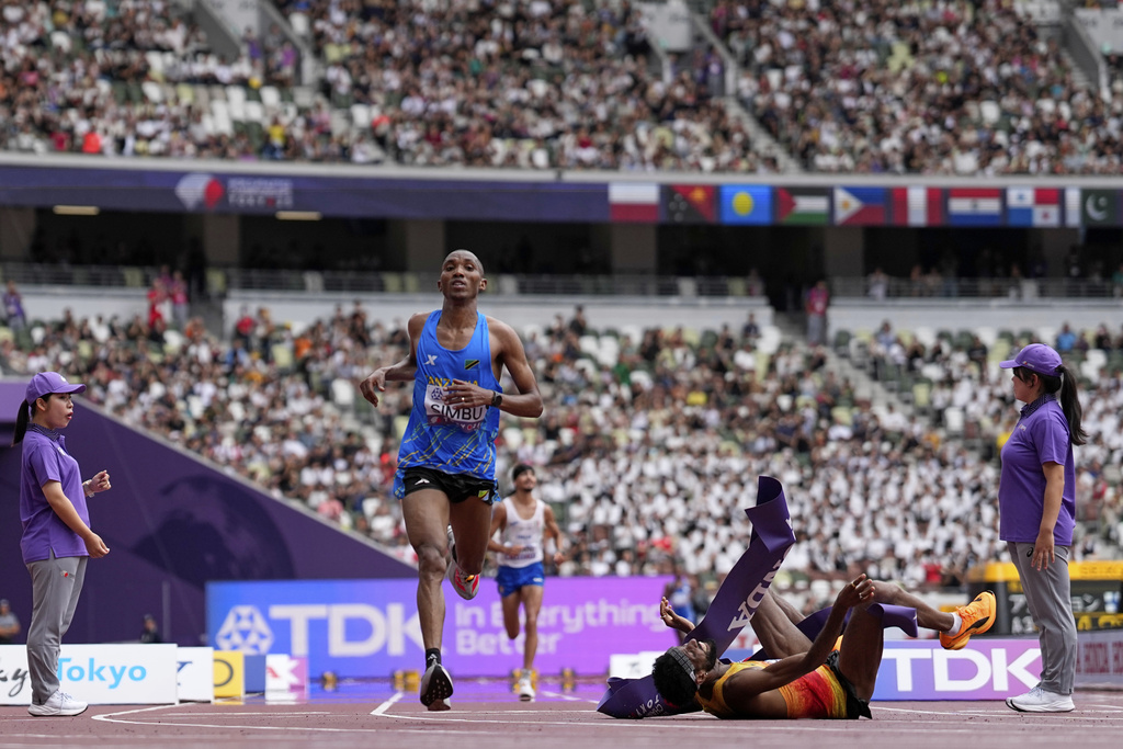 Tanzania's Alphonce Felix Simbu, left, wins the gold in the men's marathon ahead of Germany's Amanal Petros who falls at the World Athletics Championships in Tokyo, Monday, Sept. 15, 2025. (AP Photo/Petr David Josek)