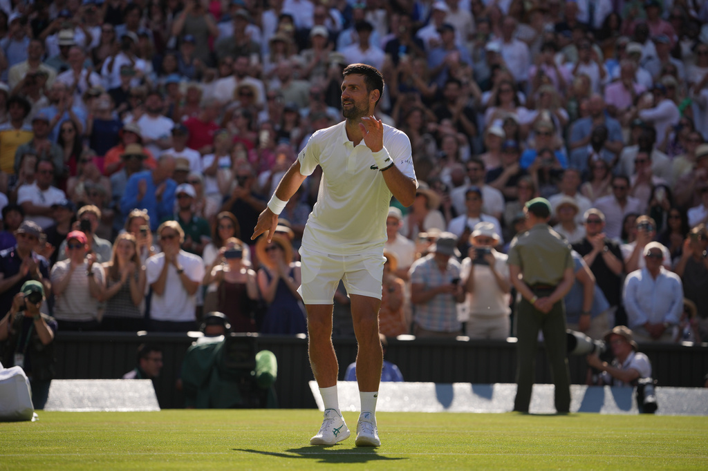 Novak Djokovic of Serbia dances towards his family as he celebrates his victory against Arthur Rinderknech of France in their third round men's singles match at the Wimbledon Tennis Championships in London, Friday, July 3, 2026. (AP Photo/Kin Cheung)