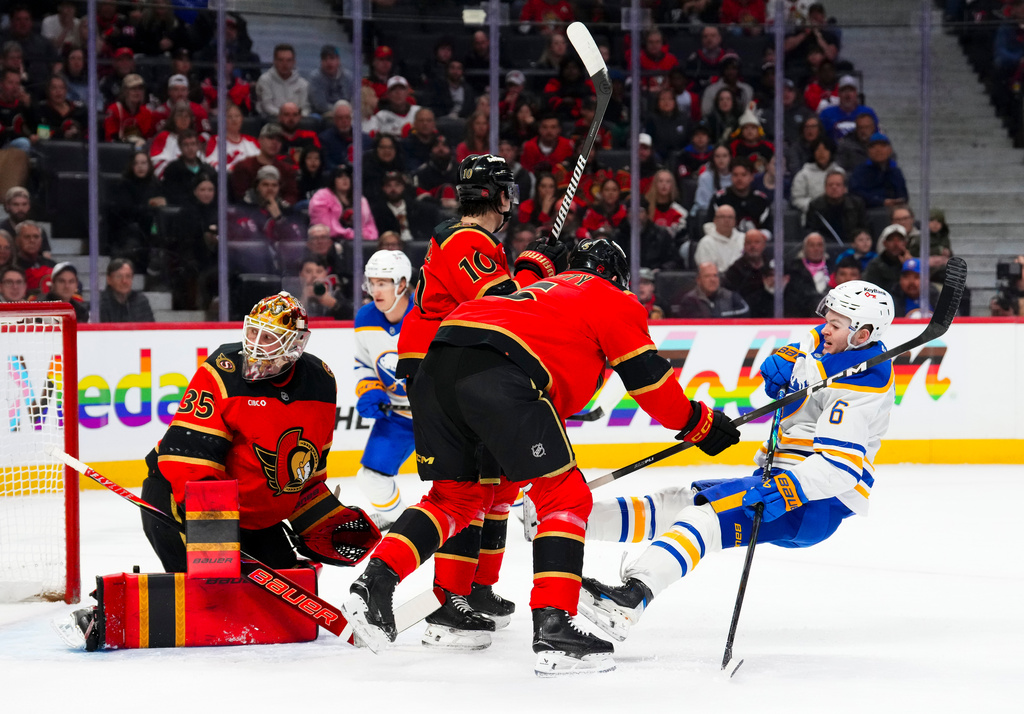 Ottawa Senators' Cameron Crotty (5) pushes Buffalo Sabres' Zach Benson (6) to the ice during first-period NHL hockey game action in Ottawa, Ontario, Thursday, April 2, 2026. (Sean Kilpatrick/The Canadian Press via AP)