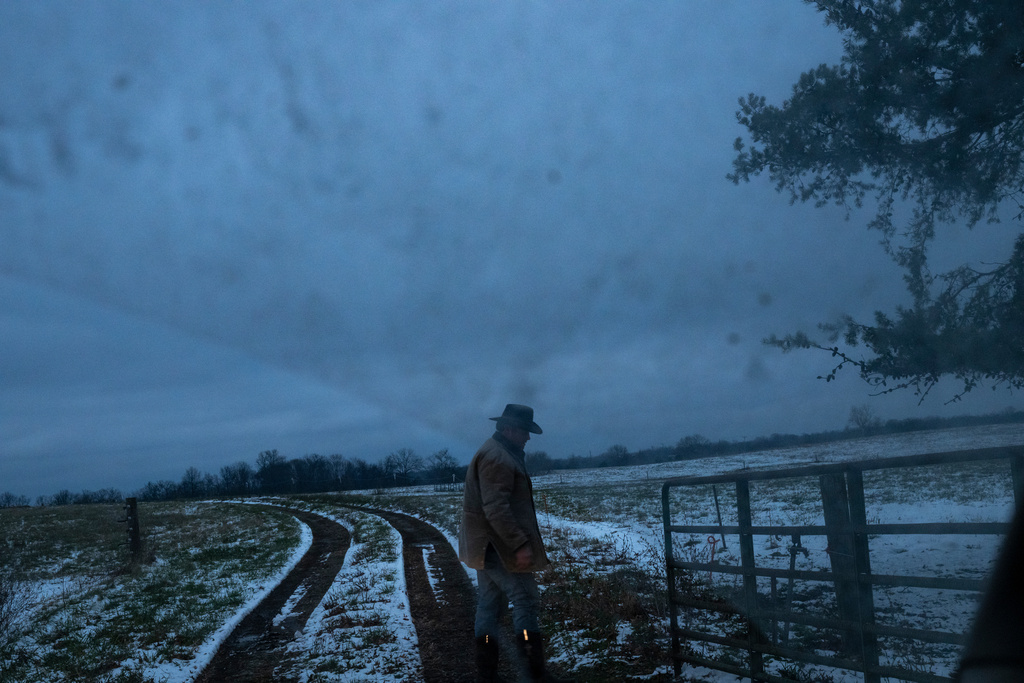 Josh Pyles, who is part of a cooperative program that helps local farmers stay on the farm and, in turn, strengthen rural communities, opens a gate to check on a herd of cattle in Henry County, Ky., Saturday, Dec. 13, 2025. (AP Photo/Michael Swensen)