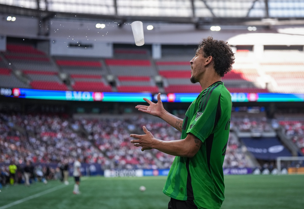 Austin FC's Guilherme Biro has a drink thrown at him by a spectator as he walks off the field after receiving his second yellow card, resulting in a red card, during the second half of an MLS soccer match against the Vancouver Whitecaps in Vancouver, British Columbia, Sunday, Sept. 13, 2026. (Darryl Dyck/The Canadian Press via AP)