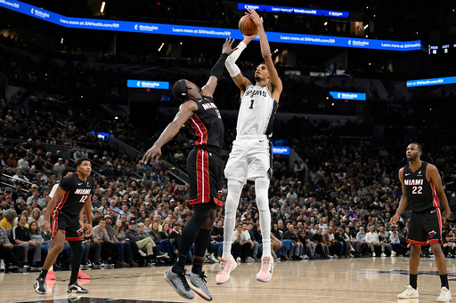 San Antonio Spurs center Victor Wembanyama (1) goes up to shoot against Miami Heat forward Bam Adebayo, center left, during the second half of an NBA basketball game, Thursday, Oct. 30, 2025, in San Antonio. (AP Photo/Darren Abate) San Antonio Spurs center Victor Wembanyama (1) goes up to shoot against Miami Heat forward Bam Adebayo, center left, during the second half of an NBA basketball game, Thursday, Oct. 30, 2025, in San Antonio. (AP Photo/Darren Abate)