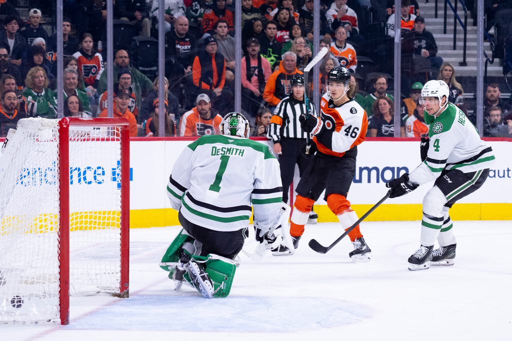Philadelphia Flyers center Trevor Zegras, center, shoots the puck past Dallas Stars goalie Casey DeSmith, left, for the game winning goal as defenseman Miro Heiskanen, right, is defending during overtime of an NHL hockey game, Sunday, March 29, 2026, in Philadelphia. (AP Photo/Chris Szagola)