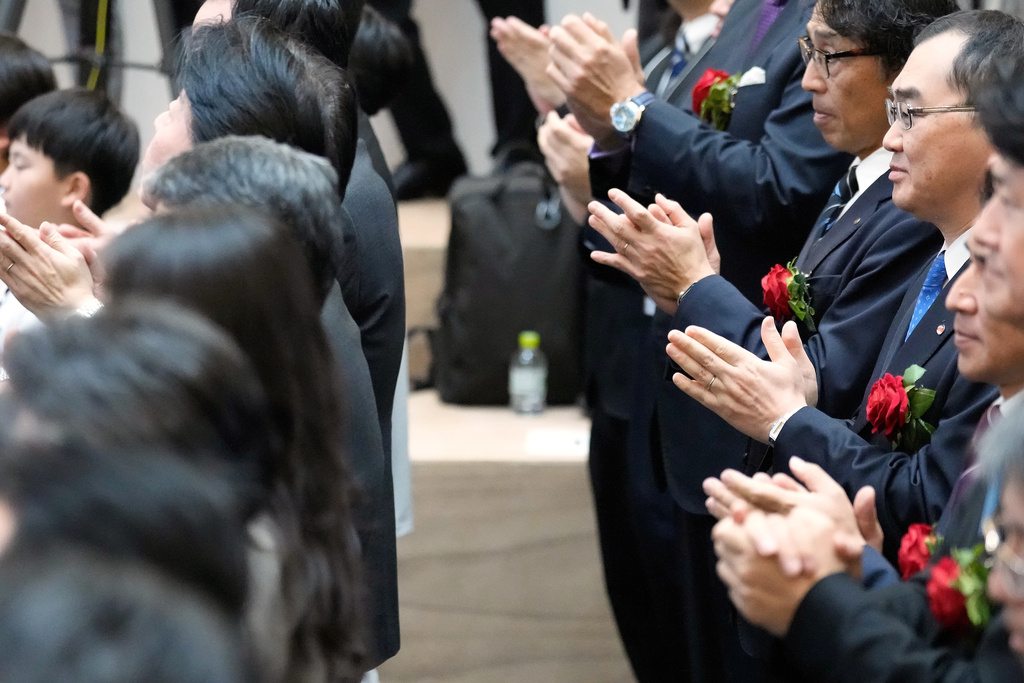 Participants perform a traditional hand clap at the end of a ceremony to conclude the year's trading at the Tokyo Stock Exchange Tuesday, Dec. 30, 2025, in Tokyo. (AP Photo/Eugene Hoshiko)