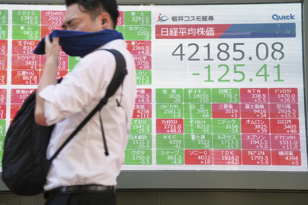 A person walks in front of an electronic stock board showing Japan's Nikkei index at a securities firm Wednesday, Sept. 3, 2025, in Tokyo. (AP Photo/Eugene Hoshiko)