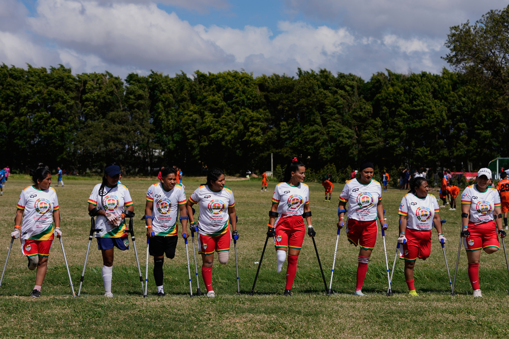 Palyers stand on the field prior to playing during a women's amputee soccer clinic in Santa Cruz, Bolivia, Friday, July 17, 2026. (AP Photo/Juan Karita)