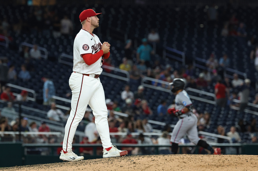 Washington Nationals pitcher Mitchell Parker rubs a new baseball after surrendering a two-run home run to Miami Marlins' Heriberto Hernández as he runs the bases during the ninth inning of a baseball game, Tuesday, June 2, 2026, in Washington. (AP Photo/Terrance Williams)