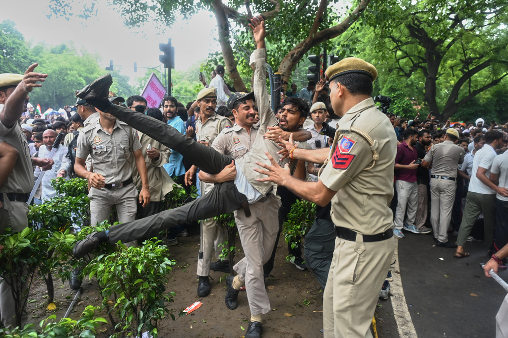 Police detains a supporter of the Cockroach Janta Party while he with others attempt to march toward India's Parliament, demanding the resignation of the education minister, in New Delhi, Monday, July 20, 2026. (AP Photo/Vipin)