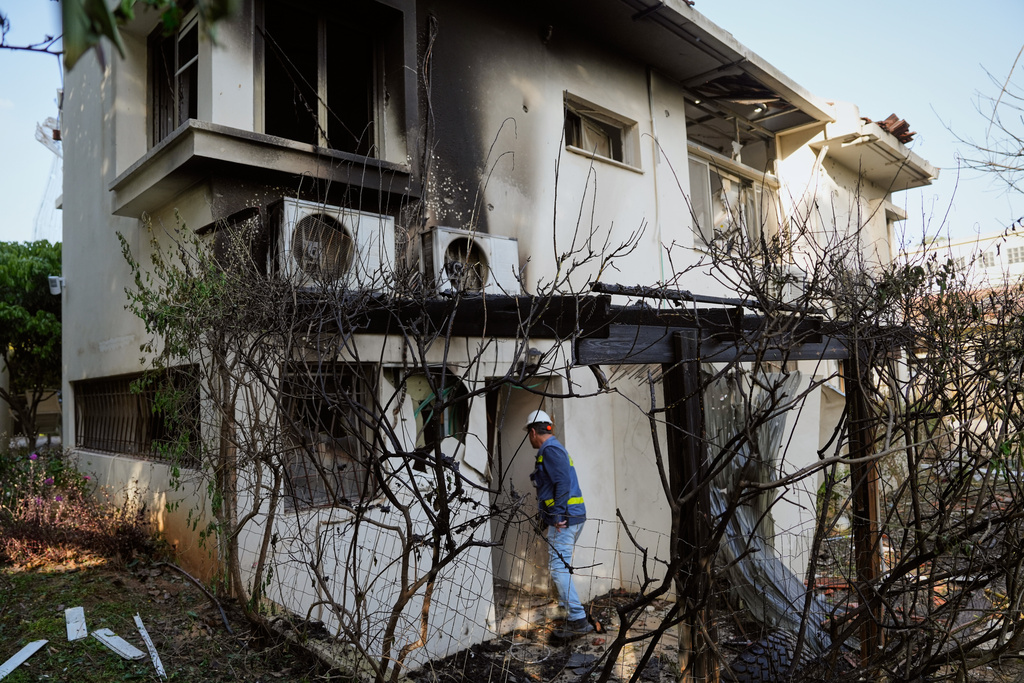 Israeli authorities inspect homes damaged by a projectile launched from Lebanon, in Haniel central Israel, Thursday, March 12, 2026. (AP Photo/Baz Ratner)