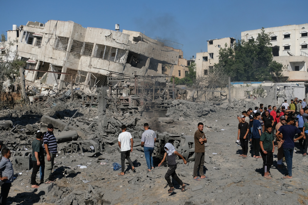 Palestinians gather around the site of an Israeli military drone strike on a blacksmith shop in Gaza City's Sabra neighborhood killing at least four Palestinians and wounded another, according to officials at Shifa hospital, where the casualties were taken on Sunday, July 12, 2026. (AP Photo/Jehad Alshrafi)