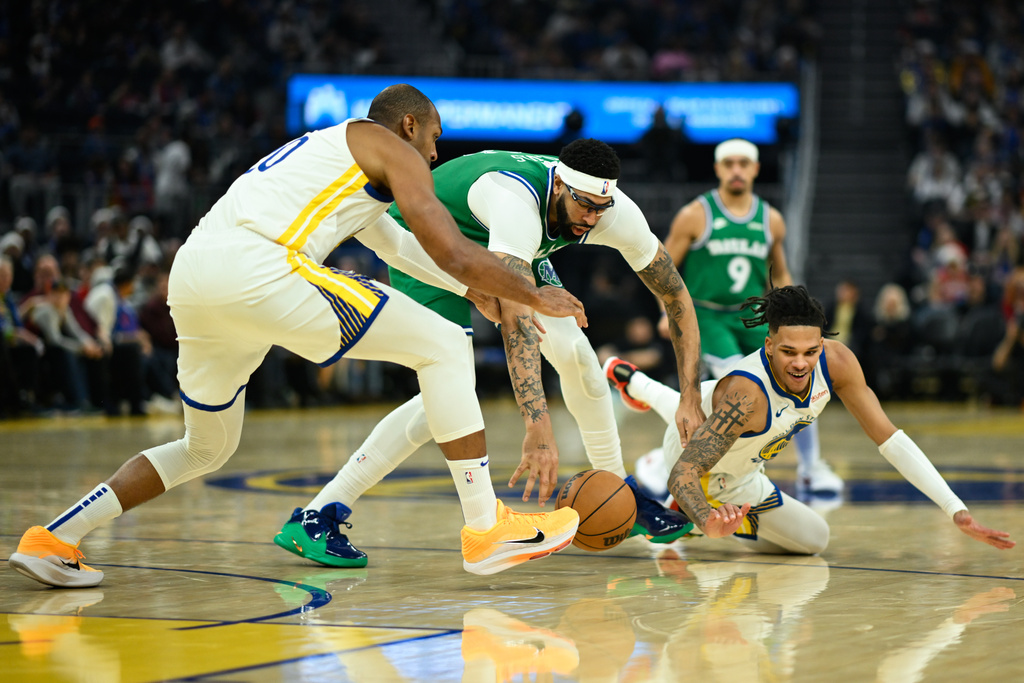 Dallas Mavericks forward Anthony Davis, center, Golden State Warriors center Al Horford, left, and guard Will Richard, right, reach for a loose ball during the first half of an NBA basketball game Thursday, Dec. 25, 2025, in San Francisco. (AP Photo/Eakin Howard)