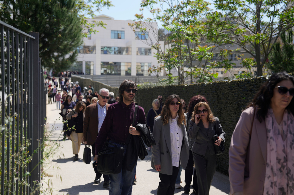 People leave a courthouse after a gunman opened fire leaving several people wounded in Athens, Tuesday, April 28, 2026. (AP Photo/Petros Giannakouris)