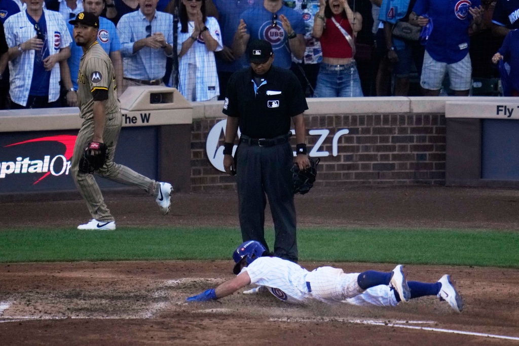 Chicago Cubs' Dansby Swanson slides into home on a sacrifice fly by Nico Hoerner during the eighth inning of Game 1 of a National League wild card baseball game against the San Diego Padres Tuesday, Sept. 30, 2025, in Chicago. (AP Photo/Erin Hooley)