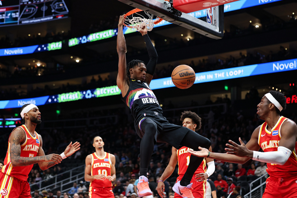 Denver Nuggets guard Peyton Watson, center, dunks during the first half of an NBA basketball game against the Atlanta Hawks, Friday, Dec. 5, 2025, in Atlanta. (AP Photo/Colin Hubbard)