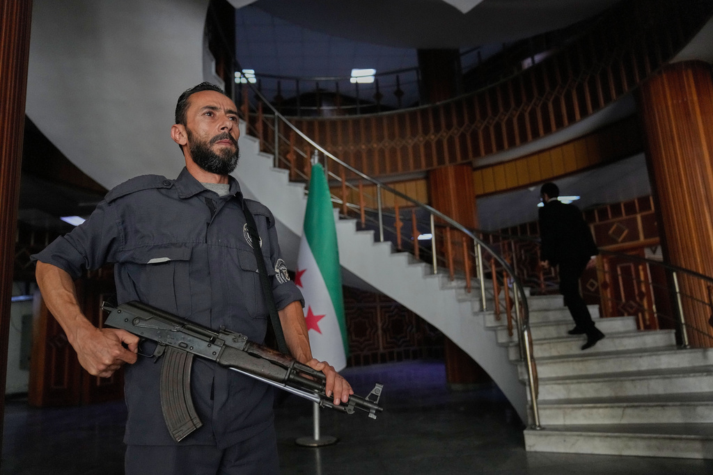 A Syrian policeman stands guard at Latakia's Governor building where the voting for a parliamentary election will take place, in the coastal city of Latakia, Syria, Sunday, Oct. 5, 2025. (AP Photo/Hussein Malla)