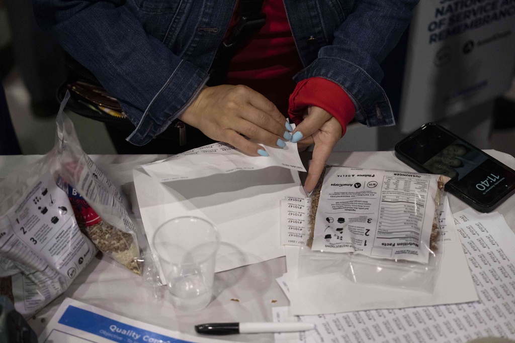 A volunteer puts labels on the bag during the "NYC Meal Pack For 9/11 Day" at the Intrepid Sea, Air & Space Museum, Wednesday, Sep. 10, 2025, in New York. (AP Photo/Yuki Iwamura)