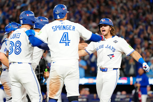 Toronto Blue Jays' Addison Barger, right, celebrates with teammates George Springer (4), Nathan Lukes, front left, and Andrés Giménez (obscured) after hitting a grand slam against the Los Angeles Dodgers during the sixth inning of Game 1 of baseball's World Series in Toronto, Friday, Oct. 24, 2025. (Frank Gunn/The Canadian Press via AP) Toronto Blue Jays' Addison Barger, right, celebrates with teammates George Springer (4), Nathan Lukes, front left, and Andrés Giménez (obscured) after hitting a grand slam against the Los Angeles Dodgers during the sixth inning of Game 1 of baseball's World Series in Toronto, Friday, Oct. 24, 2025. (Frank Gunn/The Canadian Press via AP)