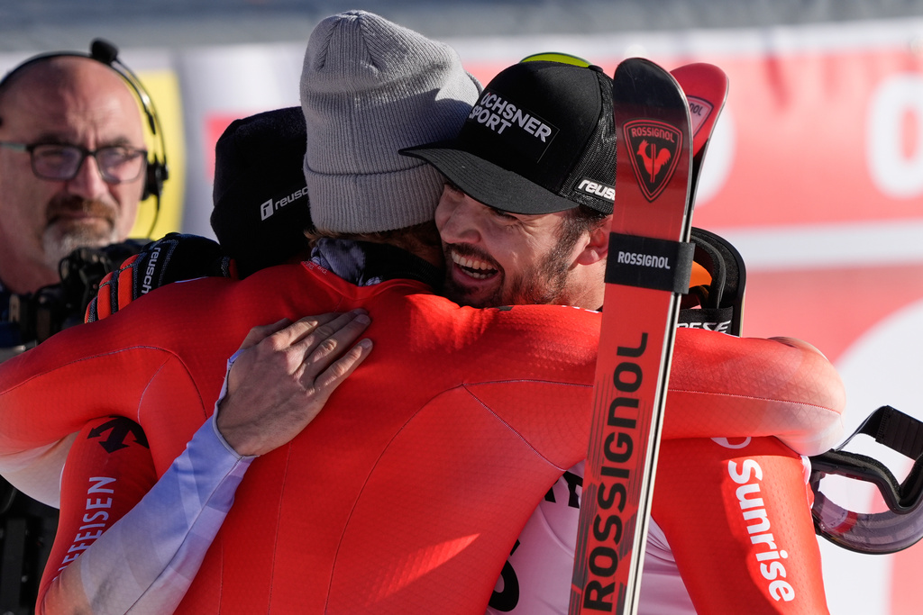 Switzerland's Loic Meillard, right, winner of an alpine ski, men's World Cup giant slalom event, celebrates with fellow-countrymen second placed Luca Aerni and third placed Marco Odermatt, center, in Val d'Isere, France, Saturday Dec. 13, 2025. (AP Photo/Giovanni Auletta)