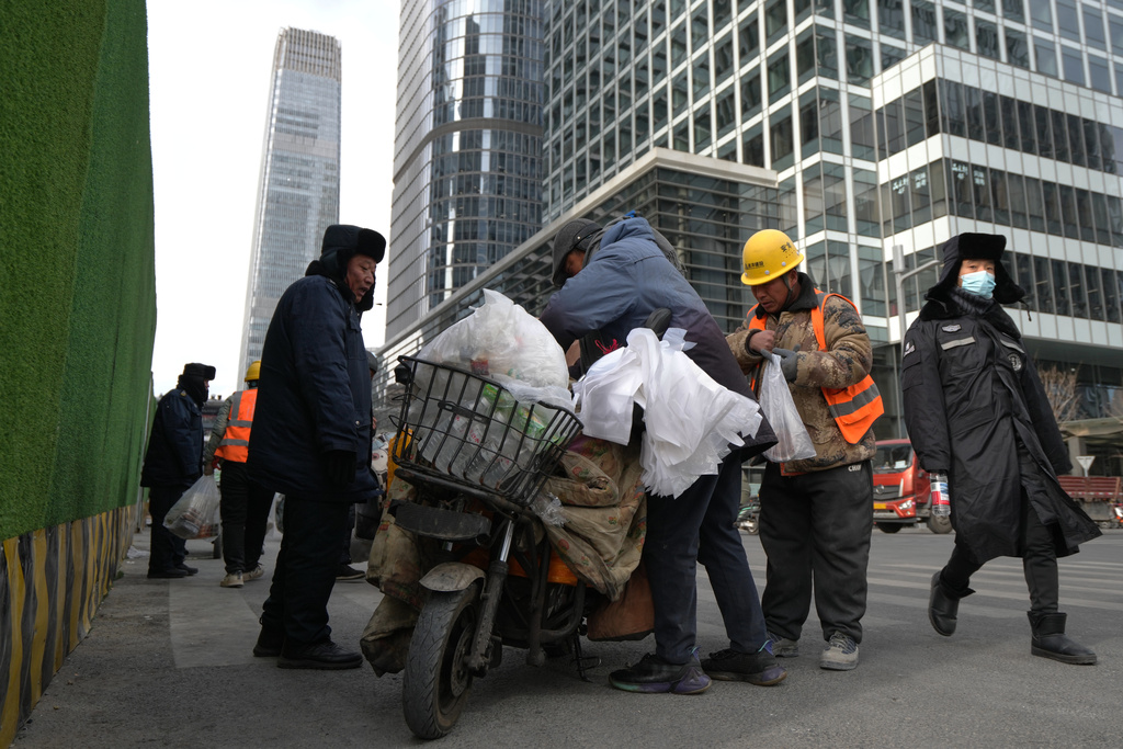 Construction workers buy their lunch meals near the office buildings at the central business district during lunch break hour in Beijing, Monday, Jan. 19, 2026. (AP Photo/Andy Wong)