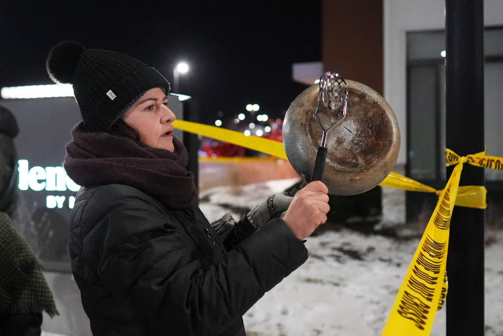 A demonstrator makes noise during a protest outside a SpringHill Suites and Residence Inn by Marriott hotels on Monday, Jan. 26, 2026, in Maple Grove, Minn. (AP Photo/Adam Gray)