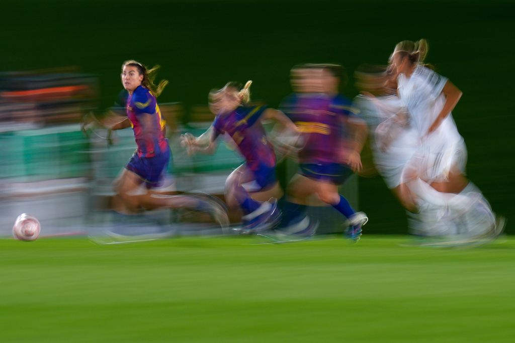 Barcelona's Patri Guijarro, left, runs with the ball during the women's Champions League quarterfinal first leg soccer match between Real Madrid and Barcelona in Madrid, Spain, Wednesday, March 25, 2026. (AP Photo/Manu Fernandez)